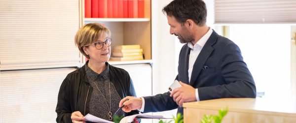 Handläggare och advokat diskuterar på kontoret.