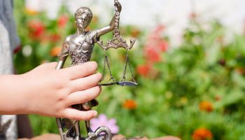 Barn håller i justitiastaty